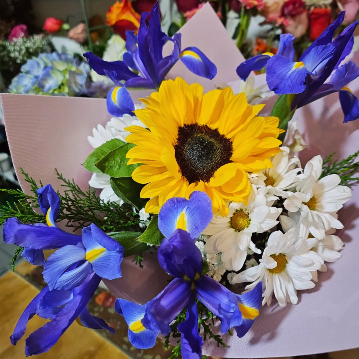 Ramo de girasoles, iris morados y flores blancas
