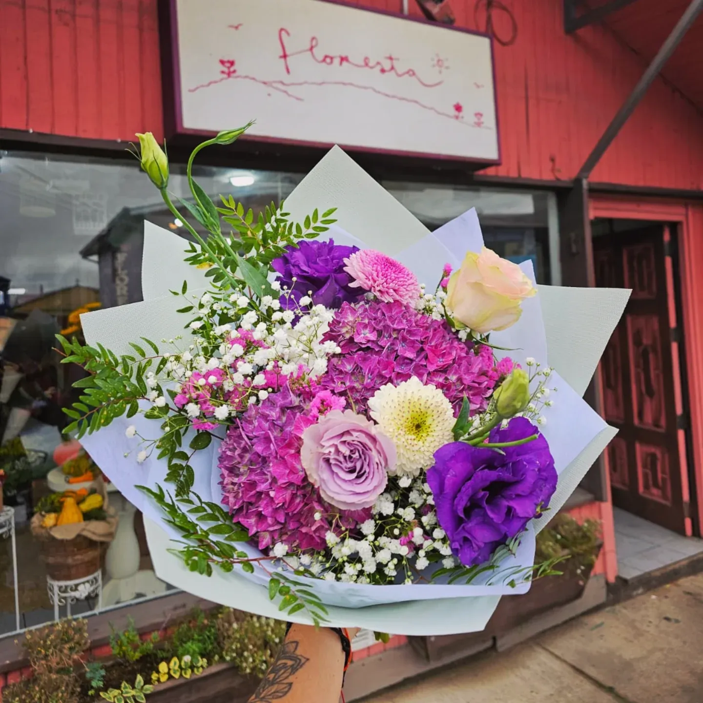 Ramo de flores moradas y lilas frente a la florería