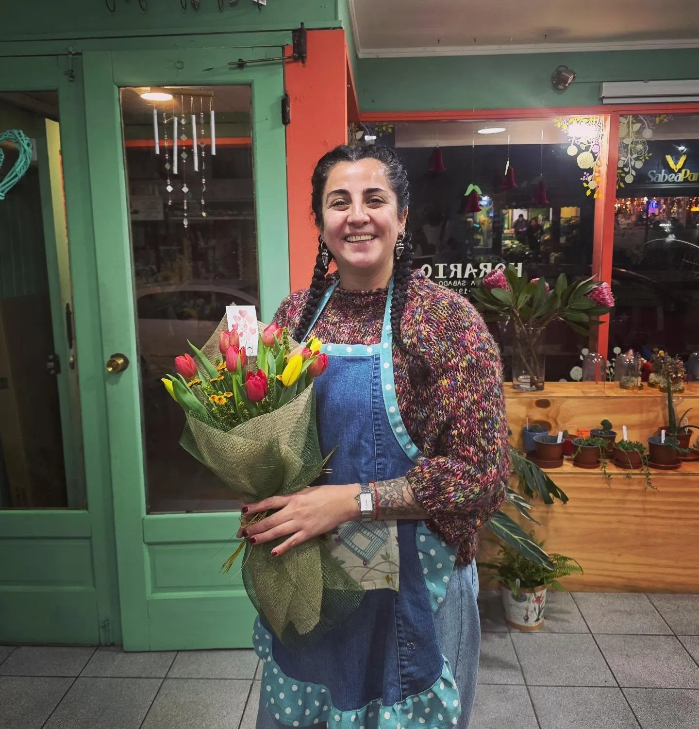 Natalia en la puerta de la florería con un ramo de tulipanes