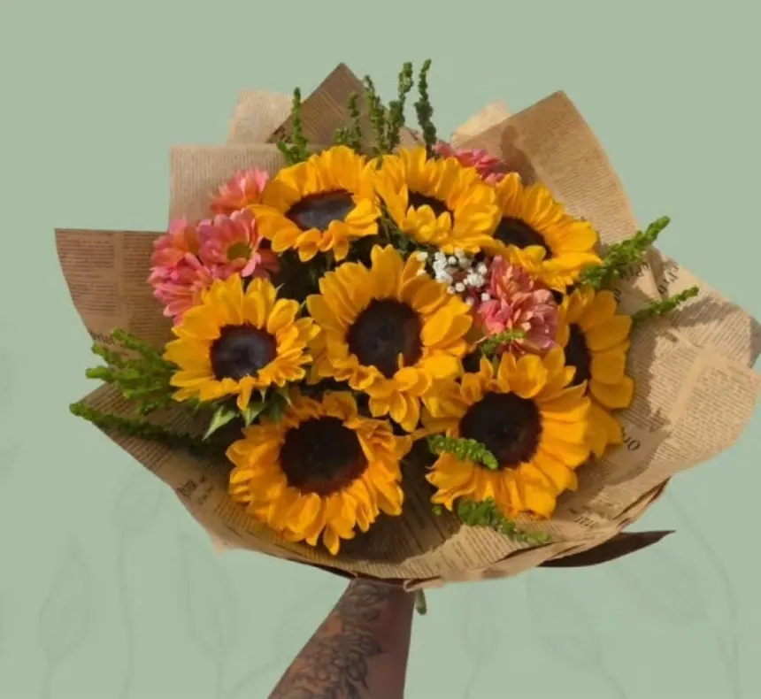Ramo de girasoles en papel kraft sostenido en alto